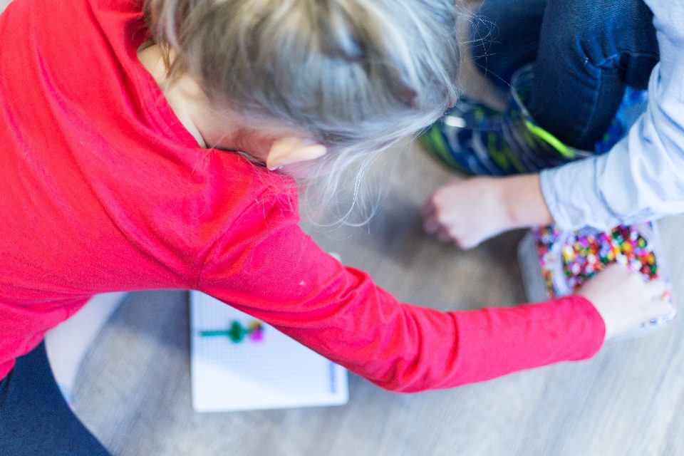 Child absorbed in a colourful craft activity