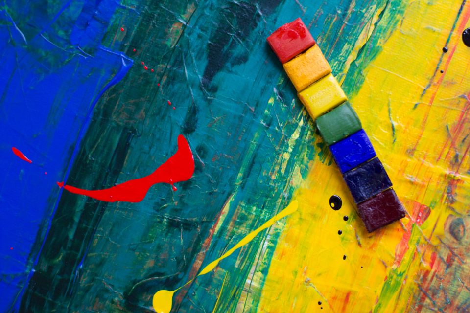 Paint pots and bright brush strokes on canvas